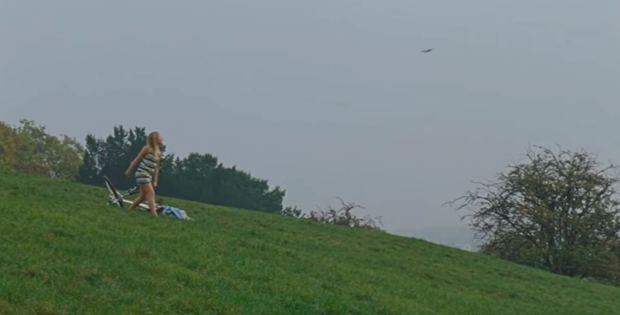 Una immagine della scena del film con la protagonista su un prato in collina